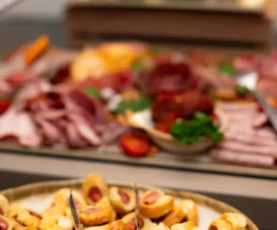 Grafika Bufet restauracyjny z zimnymi przekąskami, wędlinami, serami i chrupiącymi daniami.