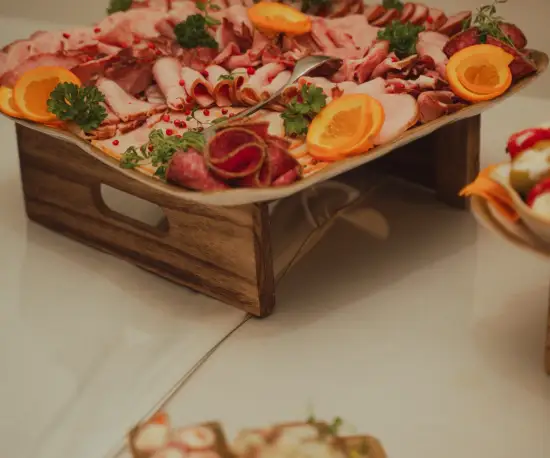 Grafika Apetyczne, kolorowe przystawki w drewnianych pojemniczkach na stole restauracyjnym.