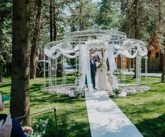 Grafika Para młoda idzie do białej altany ślubnej