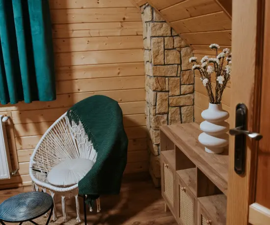 Grafika Drewniany pokój z fotelem, wazą i zieloną zasłoną Dolce Vita.