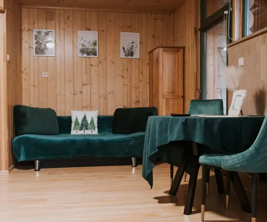 Grafika Przytulny salon i jadalnia z zielonymi meblami, drewnianymi ścianami.